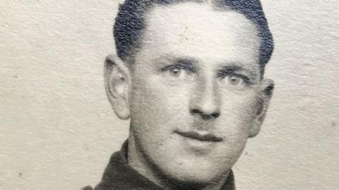 A black and white studio photo of George Whalebelly. He has short hair and his Army tunic collar can just be seen.