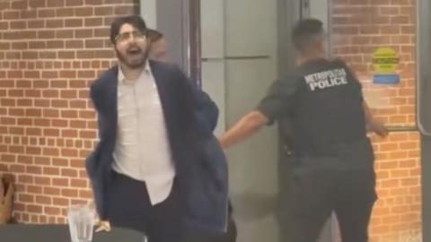 Man being taken away by police