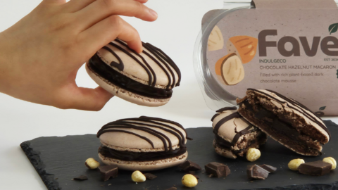 Three chocolate macarons on a black slate board
