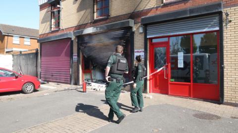 Police at the scene of the attack on the Welcome Organisation