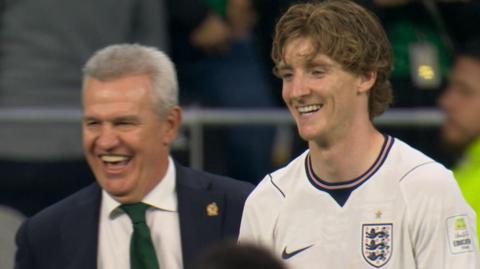 Javier Aguirre, who was manager for Mexico's game against England, and England winger Anthony Gordon share a laugh on the touchline
