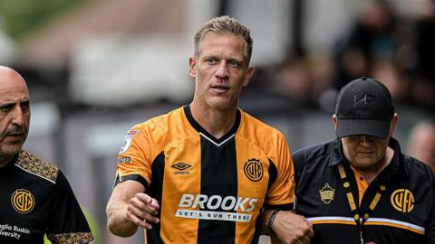 Michael Morrison is helped from the pitch after being injured in an accidental clash with his own goalkeeper