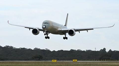 A large passenger plane comes into land at an airport.