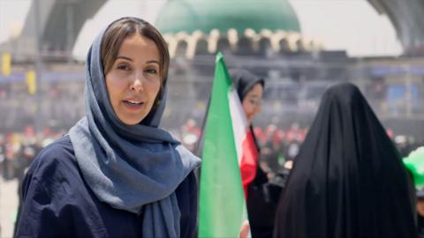 Nawal wears a lose blue hijab and abayah as she reports from the Grand Mosalla in Tehran