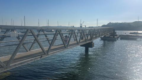 The pontoon stretching across the blue river with sunshine sparkling on the water