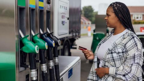 A driver paying for their petrol at a fuel pump