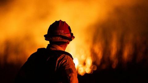 A firefighter monitors the spread of the Auto Fire in Oxnard, North West of Los Angeles, California,