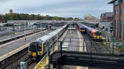 Three trains approaching a train station.