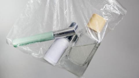 Clear bag with three small liquids in it. 