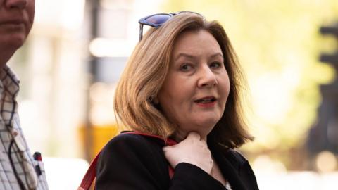 Teacher Rebecca Richardson from Cradley in Herefordshire, arrives at Westminster Magistrates' Court in London. She has shoulder-length brown hair with sunglasses on her head. 