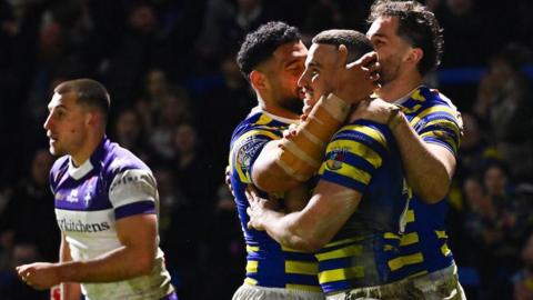 Warrington Wolves player Josh Smith is congratulated by team-mates for scoring a try against Wakefield Trinity