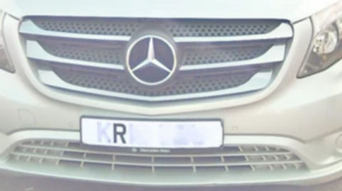 A white Mercedes number plate that only has one letter visible to a camera.