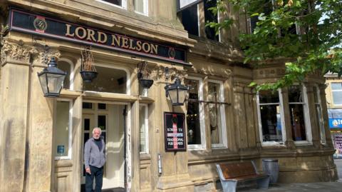 Customer smoking in the doorway of the Lord Nelson pub in Nelson