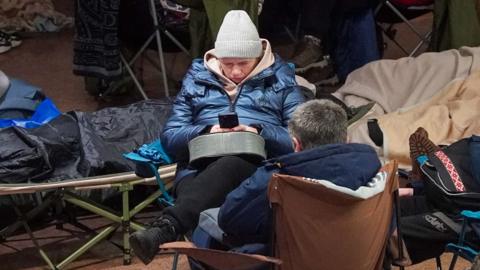 People take shelter at a metro station during a Russian air attack, in Kyiv, on early February 3, 2026.