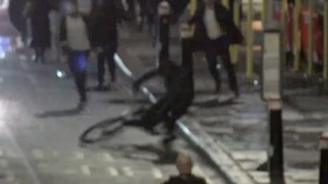 A man on a bike just before he's arrested by police