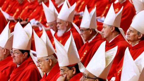 cardinals in red cloaks and white hats