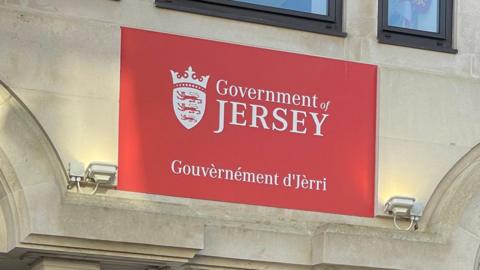 A picture of a red sign with the government logo on it.