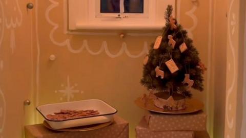 A screenshot from a video sent in of Adam Johnson's Brighton home. A Christmas tree and a tray of gingerbread men can be seen in the image.