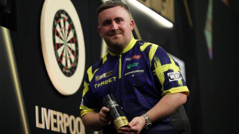 Luke Littler with the Premier League night 12 trophy