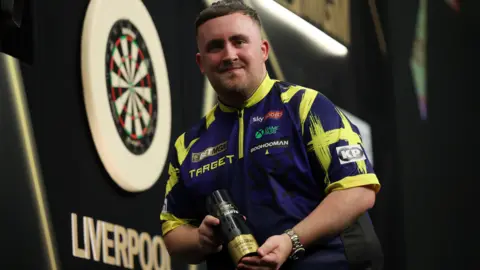 Luke Littler with the Premier League night 12 trophy