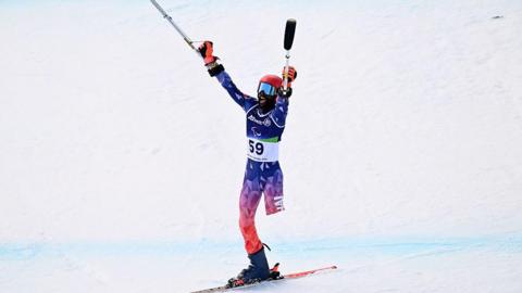 Haitian skier Ralf Etienne celebrates at the Winter Paralympics