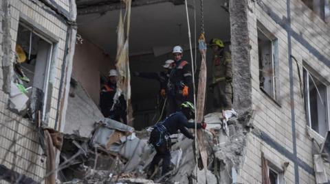 Rescuers work at the site of the apartment buildings hit during the Russian drone strike, amid Russia's attack on Ukraine, in Dnipro, Ukraine November 8, 2025.