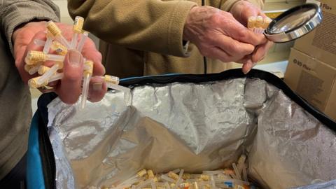 Volunteers sorting medical needles