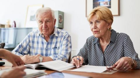 Senior couple meeting with financial consultant at home