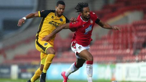 Kwame Thomas of Wrexham battles for possession with Giles Phillips