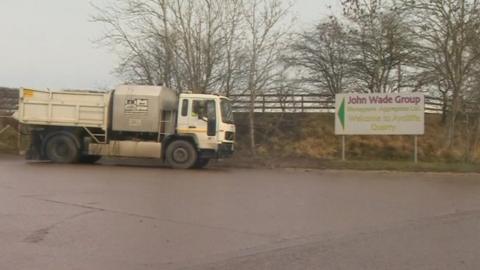 A lorry and a sign for the John Wade Group site