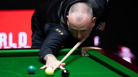 Mark Williams plays a shot