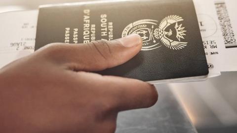 Cropped shot of an unrecognizable man handing over his ID book at a boarding gate in an airport