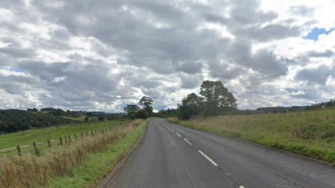The A6 is a winding rural road, which has two lanes. It is surrounded by grassland. 