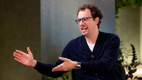 Dario Amodei, co-founder and chief executive officer of Anthropic, speaking during an interview in a room decorated with plants
