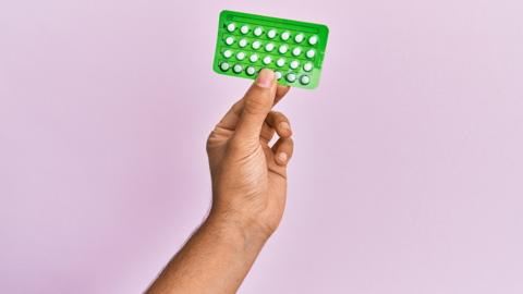 a man's hand holding pills
