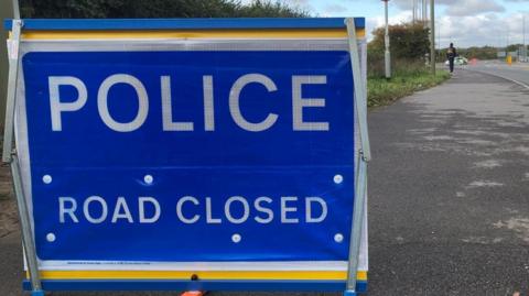 A police road closed sign