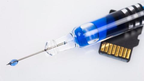 Microchip and Syringe - stock photo