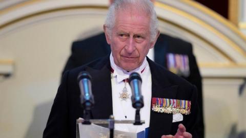 King Charles III addresses assembled guests during a dinner at Mansion House in London