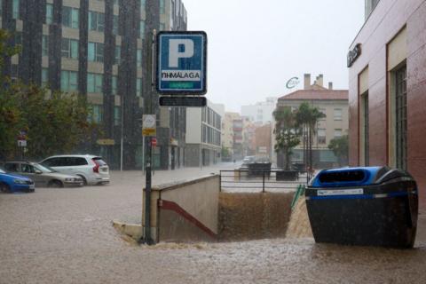 Floods in a street with cars and stairs to an underground car park.