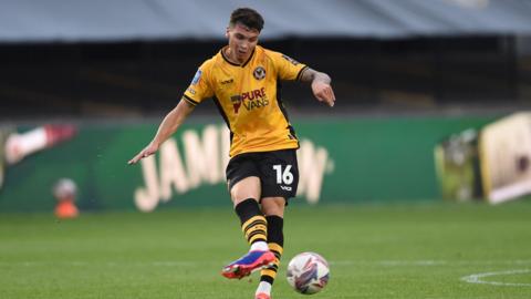 Jamie Miley passes the ball while in action for Newport County