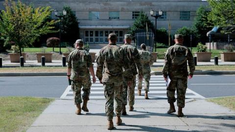 National Guard troops walk on the sidewalk in Washington DC