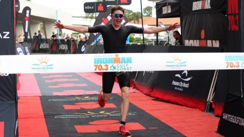 An athlete finishing an Ironman event