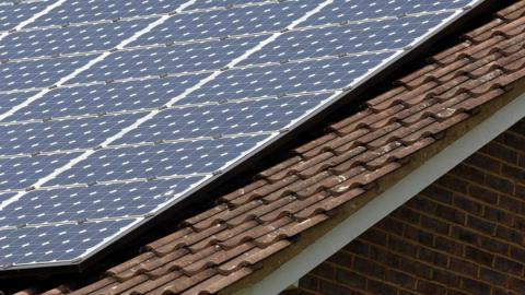 A building's slate roof where solar panels have been installed. 