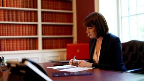 Rachel Reeves sitting holding a pen at a desk in Number 11 Downing Street