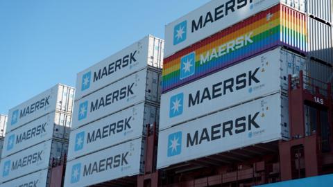 Close up of about 12 Maersk-branded shipping containers on a cargo ship