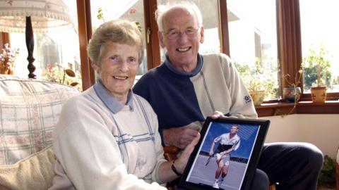 Roy and Shirley Erskine holding a photo of Andy Murray after his victory in the 2004 Junior US Open