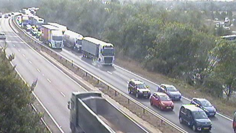 A traffic camera image of the A14 showing a queue of cars on the westbound carriageway