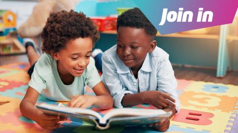 Two boys are lying on their bellies on a brightly coloured mat. They are reading a book together. In the top right hand corner is a graphic which says Join in.