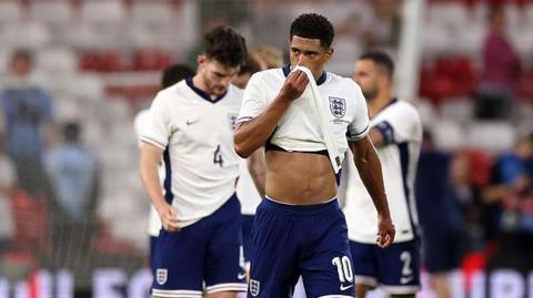Jude Bellingham wipes his face with his shirt after England's 3-1 defeat by Senegal