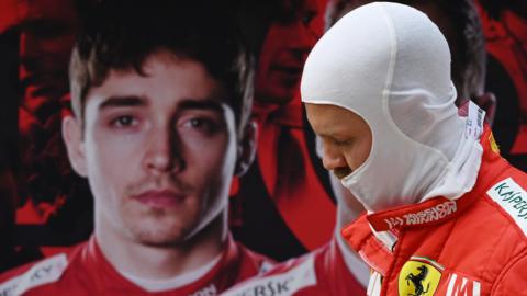 Sebastian Vettel walks past a poster of Charles Leclerc